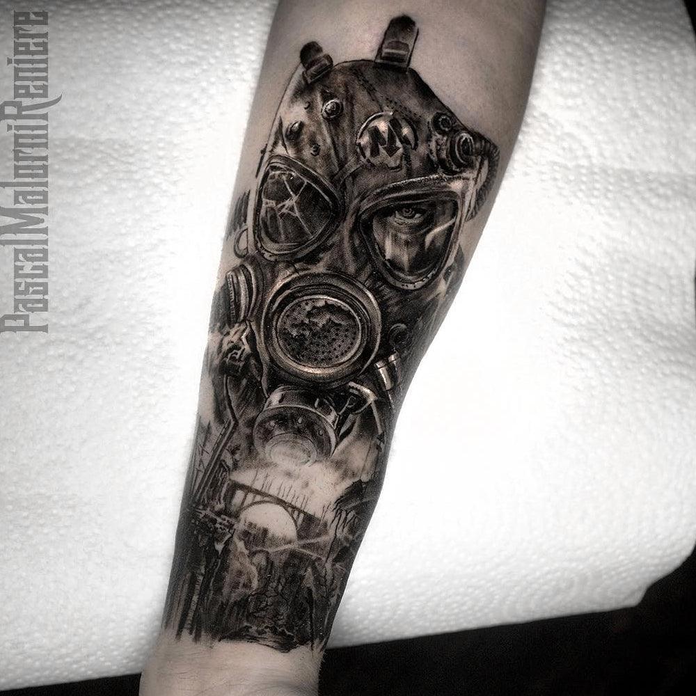 Surreal gas mask forearm tattoo by Pascal Malorni Reniere